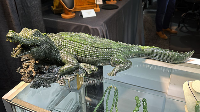 Figure 1. An alligator measuring roughly 29 × 11 × 9 inches fashioned from fine nephrite from the Polar mine in British Columbia. This exceptional hand-carved work was purchased at GJX on opening day. Photo by Jennifer Stone-Sundberg; courtesy of Jade West Corp. Figure 1. An alligator measuring roughly 29 × 11 × 9 inches fashioned from fine nephrite from the Polar mine in British Columbia. This exceptional hand-carved work was purchased at GJX on opening day. Photo by Jennifer Stone-Sundberg; courtesy of Jade West Corp.