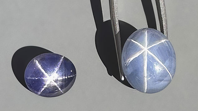 Figure 3. Exceptional star sapphires from Nivithigala, Sri Lanka, viewed in sunlight: a 7.45 ct purple color-change star sapphire (left) and a 19.74 ct light grayish blue star sapphire exhibiting an extraordinarily sharp and distinct star (right). Photo by Jennifer Stone-Sundberg; courtesy of Dudley Blauwet Gems. Figure 3. Exceptional star sapphires from Nivithigala, Sri Lanka, viewed in sunlight: a 7.45 ct purple color-change star sapphire (left) and a 19.74 ct light grayish blue star sapphire exhibiting an extraordinarily sharp and distinct star (right). Photo by Jennifer Stone-Sundberg; courtesy of Dudley Blauwet Gems.