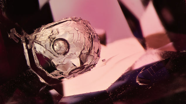 A mobile bubble floating in a cavity in spinel observed under diffused transmitted light. The nature of the substance inside the cavity remains a mystery. Photomicrograph by E. Billie Hughes; field of view ~3.5 mm. A mobile bubble floating in a cavity in spinel observed under diffused transmitted light. The nature of the substance inside the cavity remains a mystery. Photomicrograph by E. Billie Hughes; field of view ~3.5 mm.