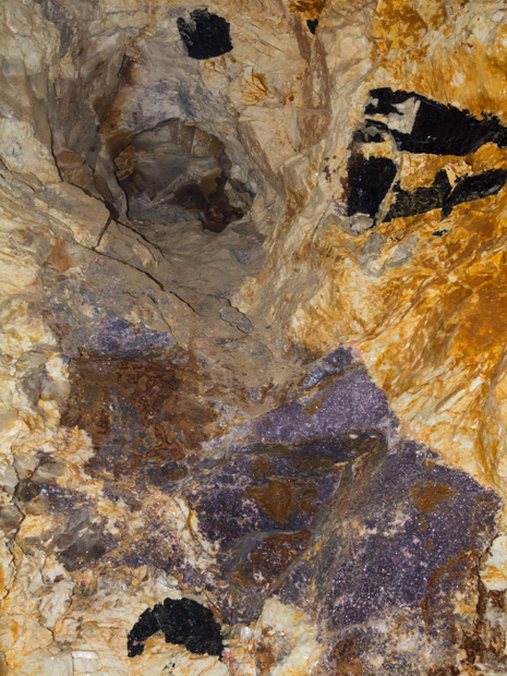 Pocket wall with lepidolite, albite, iron-manganese staining, and tourmaline indicators at Cruzeiro Mine — credit: GIA / Andy Lucas