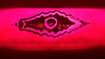 The reflection of a flux-healed fissure from a step pavilion facet in this Mong Hsu ruby resembles an evil eye. Photomicrograph by Ungkhana Atikarnsakul; field of view 1.07 mm.