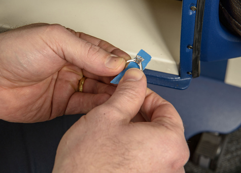 Jeweler wrapping a platinum solitaire using masking tape Jeweler wrapping a platinum solitaire using masking tape