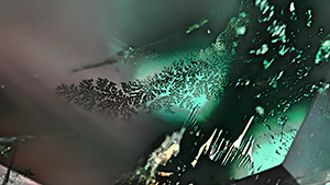 Figure 1. This 0.73 ct octagonal step cut was composed of chrysoberyl and alexandrite. The alexandrite portion showed a color change from blue-green in fluorescent light to red-purple in incandescent light. Photos by Shunsuke Nagai.