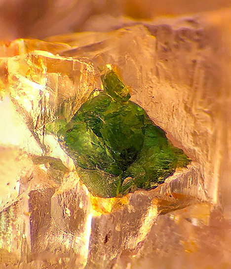 Figure 1. An aegirine crystal inclusion in poudretteite rough from Mogok, viewed with oblique fiber-optic illumination. Photomicrograph by Kyaw Thu; field of view 2.3 mm. Figure 1. An aegirine crystal inclusion in poudretteite rough from Mogok, viewed with oblique fiber-optic illumination. Photomicrograph by Kyaw Thu; field of view 2.3 mm.
