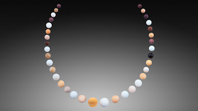 Figure 2. The 35 near-round and round non-nacreous pearls, 482.01 carats total, arranged in a necklace layout. Photo by Nuttapol Kitdee.