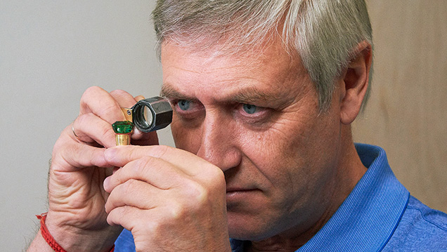Tuzlukov examines the square cushion-cut tsavorite. Tuzlukov examines the square cushion-cut tsavorite.