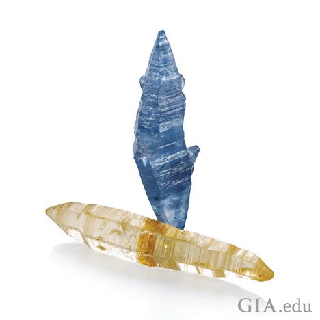 图片中显示了两个蓝宝石晶体,一个为蓝色,另一个为黄白色。 图片中显示了两个蓝宝石晶体,一个为蓝色,另一个为黄白色。