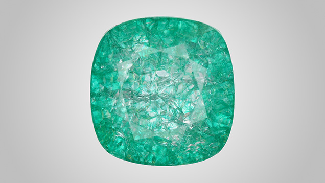 Figure 1. Face-up appearance of a quench-crackled and dyed laboratory-grown colorless sapphire, measuring 13.10 × 12.73 × 7.51 mm. Photo by Adriana Gudino. Figure 1. Face-up appearance of a quench-crackled and dyed laboratory-grown colorless sapphire, measuring 13.10 × 12.73 × 7.51 mm. Photo by Adriana Gudino.