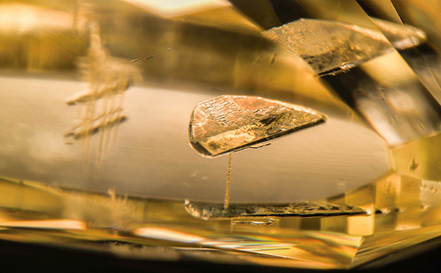 Laboratory-grown diamond contains a flux inclusion and laser drill holes. Laboratory-grown diamond contains a flux inclusion and laser drill holes.