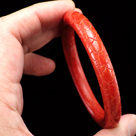 Carved bangle composed of a coral-epoxy composite. Carved bangle composed of a coral-epoxy composite.