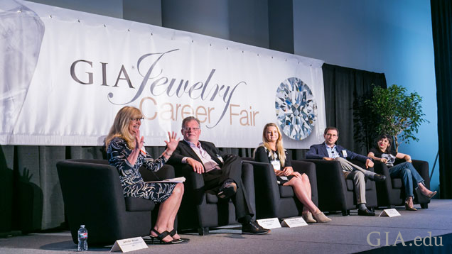 Five people sitting down on stage during a panel discussion at the GIA Jewelry Career Fair in New York City.