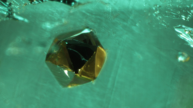 A pseudo-icosahedral crystal of pyrite in a 2.88 ct Colombian emerald. Photomicrograph by Taku Okada; field of view 1.01 mm. A pseudo-icosahedral crystal of pyrite in a 2.88 ct Colombian emerald. Photomicrograph by Taku Okada; field of view 1.01 mm.