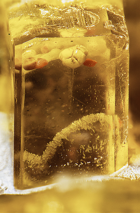Inclusions identified as orpiment, a yellow arsenic sulfide.