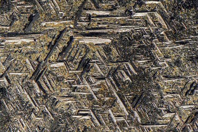 Rutile crystals in a geometric pattern on the surface of hematite.