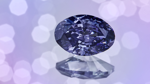 An oval shaped purple diamond on a pink, green, blue and white background. An oval shaped purple diamond on a pink, green, blue and white background.