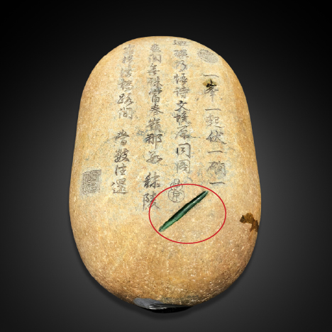 Window in this purported jadeite rough stone reveals a green underlying material.