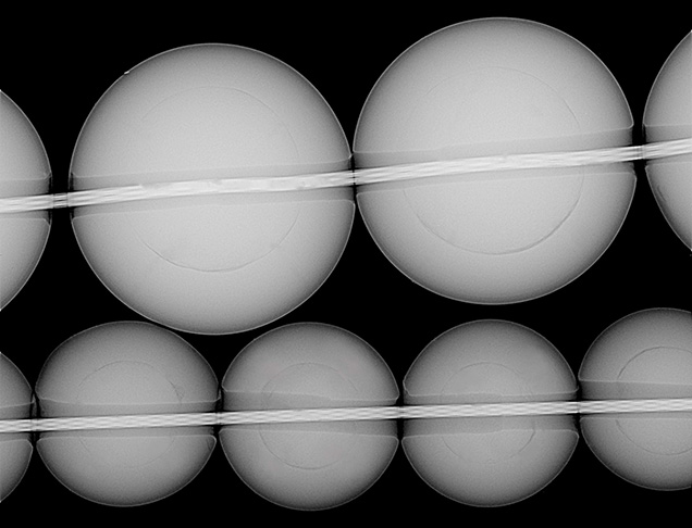 Figure 3. RTX image of freshwater BC pearls. The top strand, submitted for identification, has an average nacre thickness of 1 mm and an average bead diameter of 3.5 mm. The bottom strand, from the Hong Kong show, has an average nacre thickness of 0.8 mm and an average bead diameter of 2.7 mm. Image by Joyce Wing Yan Ho. Figure 3. RTX image of freshwater BC pearls. The top strand, submitted for identification, has an average nacre thickness of 1 mm and an average bead diameter of 3.5 mm. The bottom strand, from the Hong Kong show, has an average nacre thickness of 0.8 mm and an average bead diameter of 2.7 mm. Image by Joyce Wing Yan Ho.