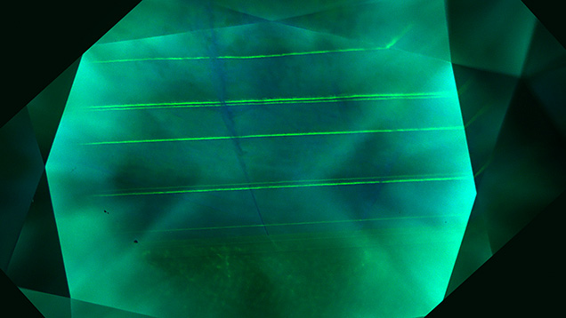 Figure 3. DiamondView imaging revealed that the channel was surrounded by blue-fluorescing dislocation bundles extending across the growth layers of the CVD diamond. Image by Elina Myagkaya.