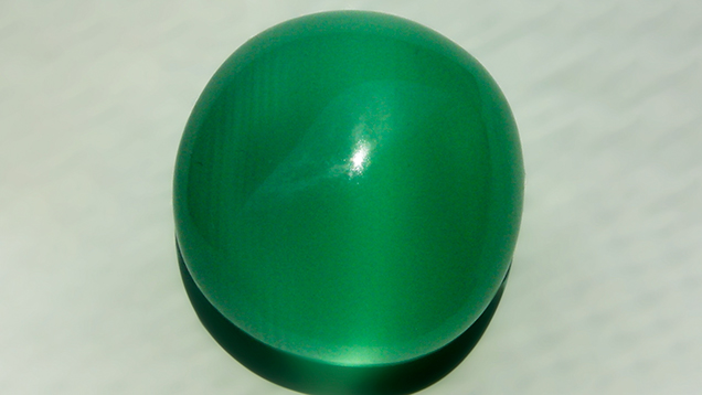 A calcite cabochon showing a cat’s eye. A calcite cabochon showing a cat’s eye.