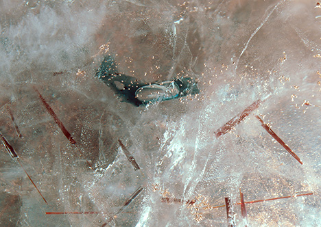 Inclusions of columbite, copper, and an air bubble within flux liquid. Inclusions of columbite, copper, and an air bubble within flux liquid.