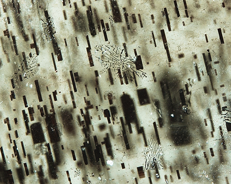 Rectangular to needle-like magnetite inclusions in star peridot. Rectangular to needle-like magnetite inclusions in star peridot.