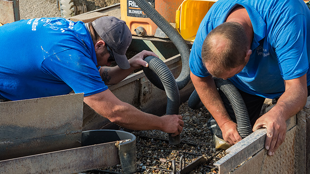 Men vacuuming dirt in the jig Men vacuuming dirt in the jig