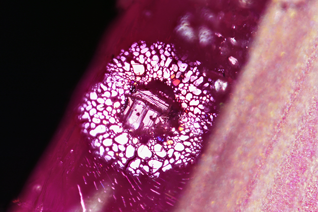 Iridescent thin films surround a negative crystal. Iridescent thin films surround a negative crystal.