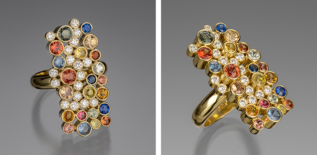 Figure 1. The “Seven Sisters” ring in 18K gold with 17 bezel-set diamonds (0.55 carats total) and 22 sapphires ranging in size from 2.5 to 4.0 mm in blue, orange, mandarin, pink, and green (3.15 carats total). Photo by Robert Weldon; courtesy of Sean Hill Designs. Figure 1. The “Seven Sisters” ring in 18K gold with 17 bezel-set diamonds (0.55 carats total) and 22 sapphires ranging in size from 2.5 to 4.0 mm in blue, orange, mandarin, pink, and green (3.15 carats total). Photo by Robert Weldon; courtesy of Sean Hill Designs.