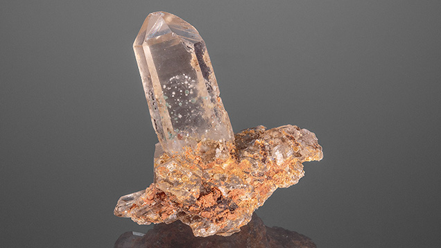 Figure 1. This quartz crystal cluster from Larimer County, Colorado, contains numerous bluish green and white spherical inclusions on phantom growth planes. Photo by Annie Haynes; courtesy of Nico Jackson.