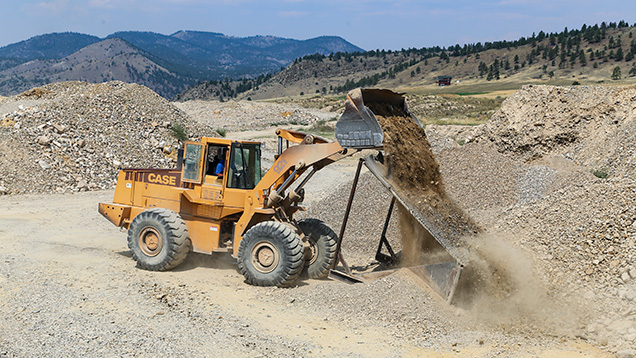 Bulldozer dumping dirt on grizzly Bulldozer dumping dirt on grizzly