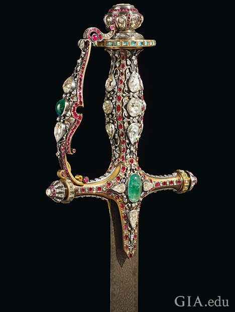 The handle of the sword is embellished with large traditional Mughal cut diamonds, rubies and emeralds. The handle of the sword is embellished with large traditional Mughal cut diamonds, rubies and emeralds.