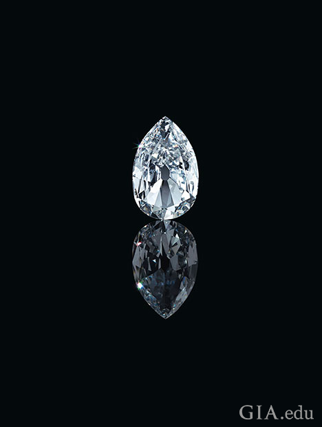 A large pear shaped diamond sits on a black background with its reflection in front of it. A large pear shaped diamond sits on a black background with its reflection in front of it.