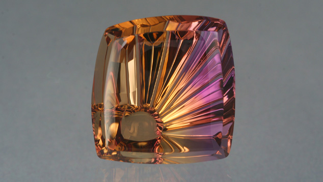 Imaginative Fantasy Cut. A unique display of ametrine’s colors blends and contrasts in this fantasy cut by noted gem designer John Dyer. He named his creation Ametrine SunRay ™. Photo by Lydia Dyer, © John Dyer & Co., gem courtesy John Dyer & Co.