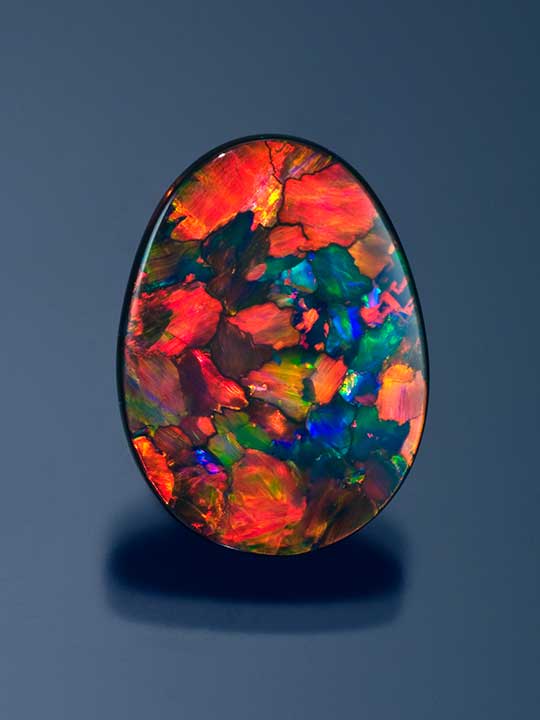 Black-Opal-68441-540x720.jpg. With a lot of red, this black opal from Lightning Ridge stands out at gem shows. Photo by Kevin Schumacher/GIA, courtesy Gerry Manning, Manning International.