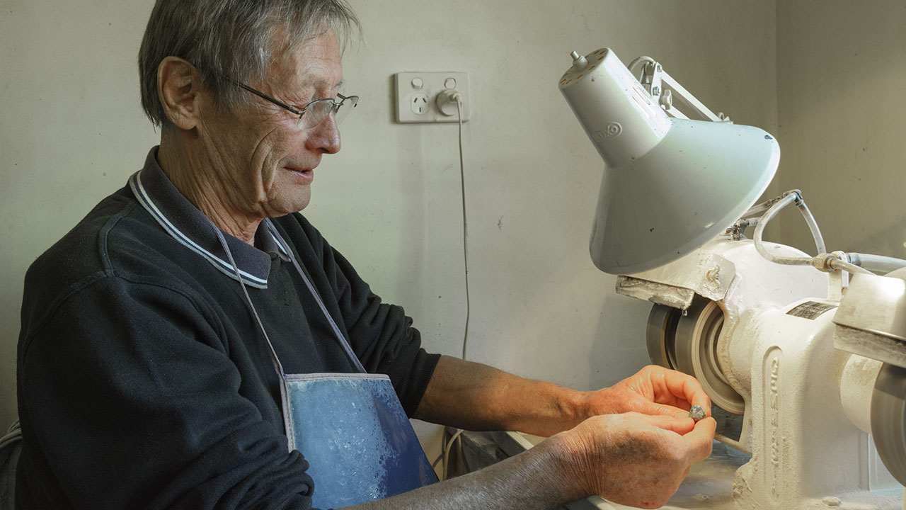 DSC_0720_185774-1280x720.jpg. All the opal mining areas had expert cutters like Jeremy Lomax. Lomax cuts for many of the miners in Lightning Ridge and used to mine himself. Many of the miners also cut a percentage of their rough. Photo by Andrew Lucas/GIA.
