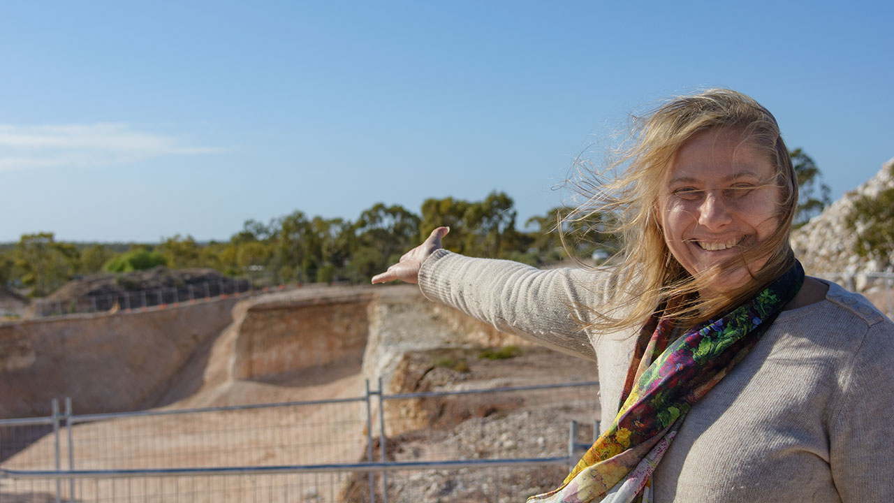 DSC_1107_185769-1280x720.jpg. As the Australian outback wind blows hard in Lightning Ridge, Jenni Brammall, manager of the Australian Opal Centre, proudly points to the site of the planned new center for education and promotion of the Australian opal industry. Photo by Andrew Lucas/GIA.