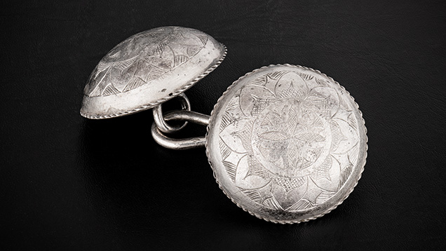 Figure 7. A set of intricately engraved silver cloak buttons. Photo by Emily Lane. Figure 7. A set of intricately engraved silver cloak buttons. Photo by Emily Lane.