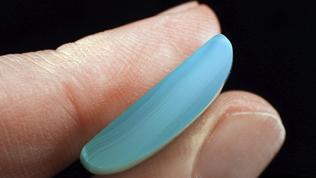 Cross-section of chalcedony cabochon shows blue mantle zoning. Cross-section of chalcedony cabochon shows blue mantle zoning.