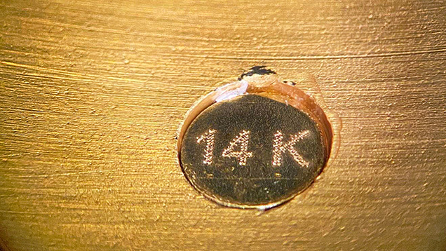Figure 2. The hallmark is not actually stamped onto the metal but is on a separate disk adhered to the inside of the bracelet. Photo by Rambod Bahadory. Figure 2. The hallmark is not actually stamped onto the metal but is on a separate disk adhered to the inside of the bracelet. Photo by Rambod Bahadory.