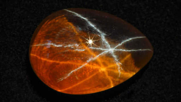 Brownish yellow synthetic sapphire with white star and brownish yellow star Brownish yellow synthetic sapphire with white star and brownish yellow star