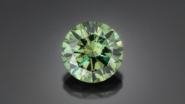 Figure 17. An 11.63 ct demantoid garnet from Namibia. Photo by Robert Weldon; courtesy of Green Dragon Mine Company, Namibia. Figure 17. An 11.63 ct demantoid garnet from Namibia. Photo by Robert Weldon; courtesy of Green Dragon Mine Company, Namibia.