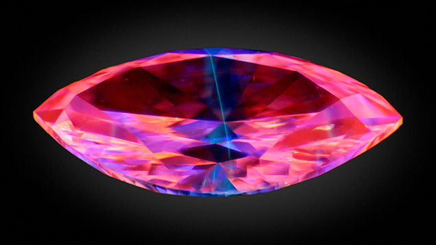 Figure 1. Deep-UV imaging of the 0.07 ct multilayered laboratory-grown diamond (4.20 × 2.26 × 1.27 mm) showing fluorescence of a thin blue-green layer between two pink-orange CVD layers. Image by Sean O’Neal.