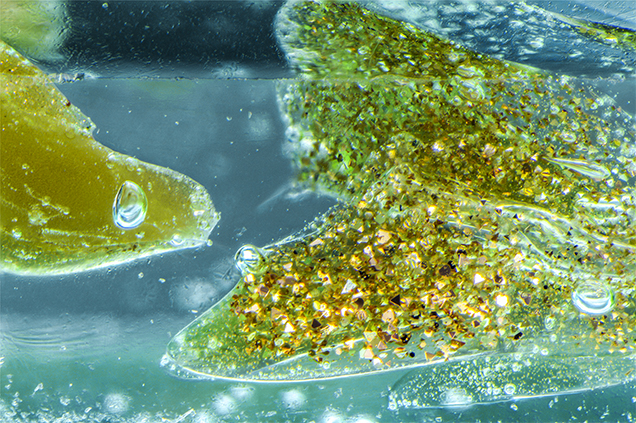 Light yellow goldstone glass containing copper crystals and gas bubbles. Light yellow goldstone glass containing copper crystals and gas bubbles.
