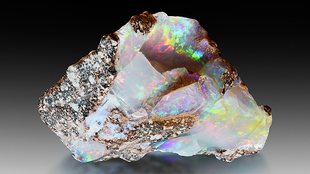 Figure 7. Precious opal in andesite host rock (28 × 22 × 14 mm). Photo by Albert Russ; courtesy of Great Rent JSC. Figure 7. Precious opal in andesite host rock (28 × 22 × 14 mm). Photo by Albert Russ; courtesy of Great Rent JSC.