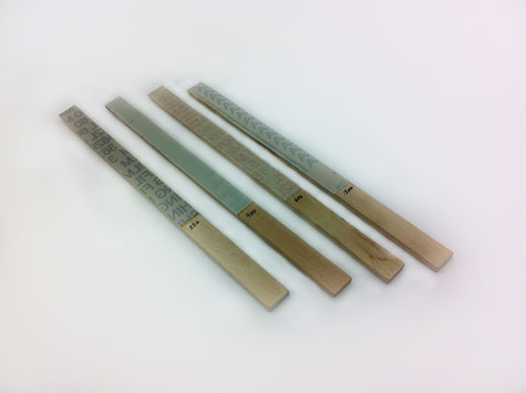 異なる4種類のグリットの精密仕上げ用フィルムを付着させた4本のスティック状研磨材。