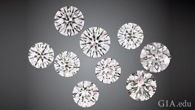 A group of nine round brilliant cut man-made diamonds on a black background.