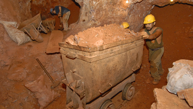 A miner pushes a cart full of waste material in the depths of Bolivia’s Anahi ametrine mine. Photo by Robert Weldon/GIA.