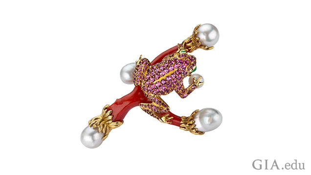 A toad made from pink tourmaline sits on a branch of coral with pearls at the ends of the branches.