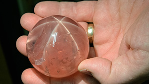 The impressive size of this museum-quality star rose quartz can be seen by comparing it to the hand that holds it.  It’s part of the gem collection at the Smithsonian Institution in Washington, DC. – Eric Welch