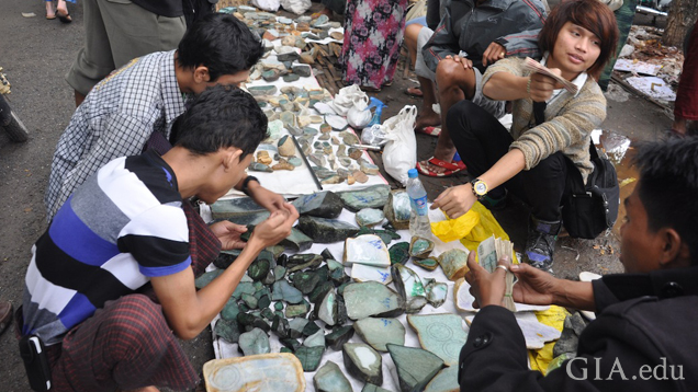 Boulders and pieces of jade are spread out on the ground for perspective buyers to view.